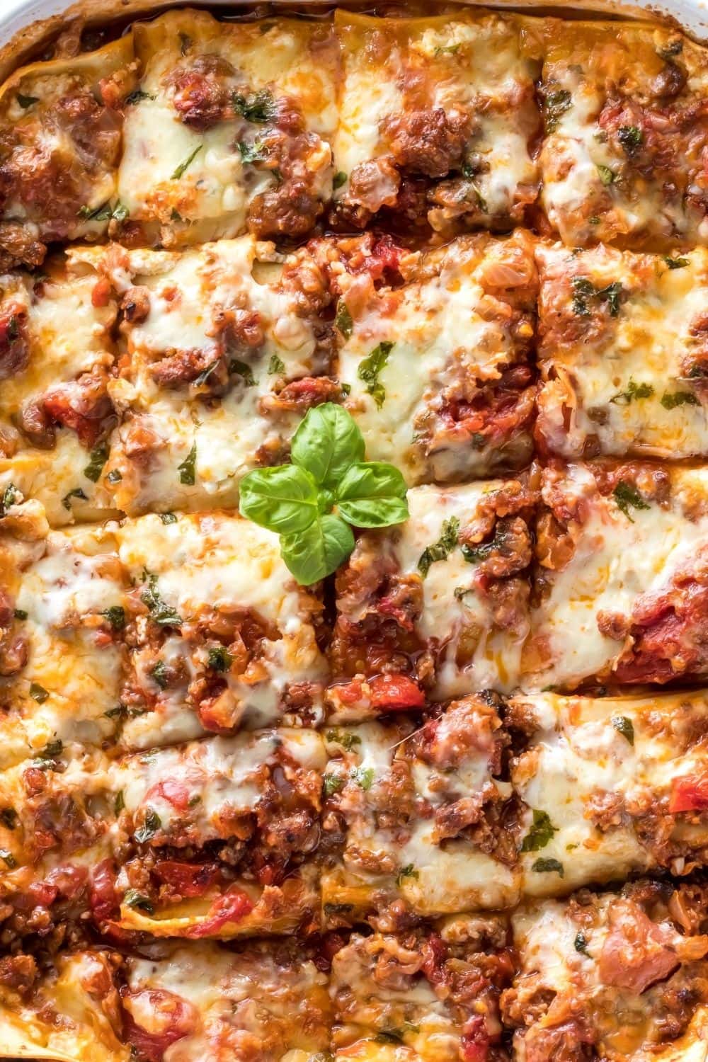 Ragu Lasagna Recipe featuring Squares of Homemade Ragu Lasagna in a Pan with Beef, Ragu, Cheese, and Basil