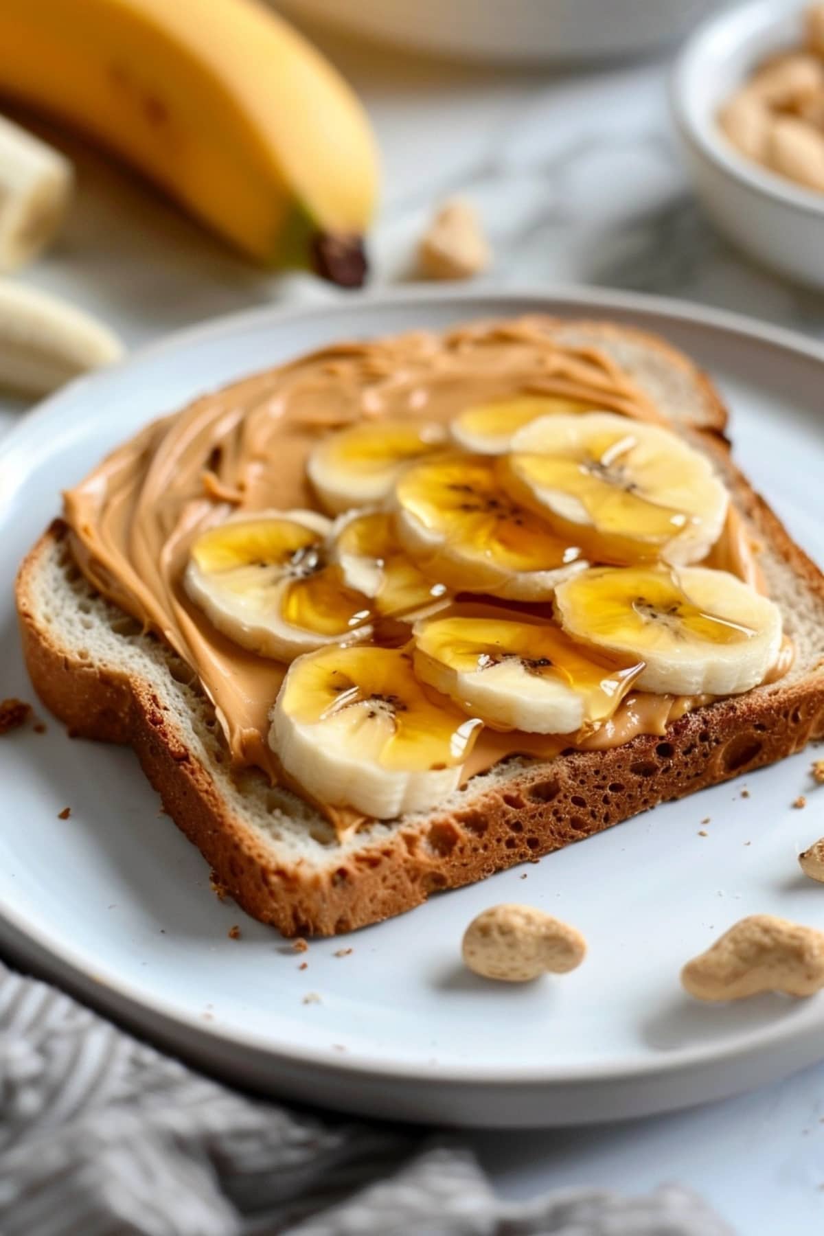 Sandwich topped with peanut butter, honey and banana filling